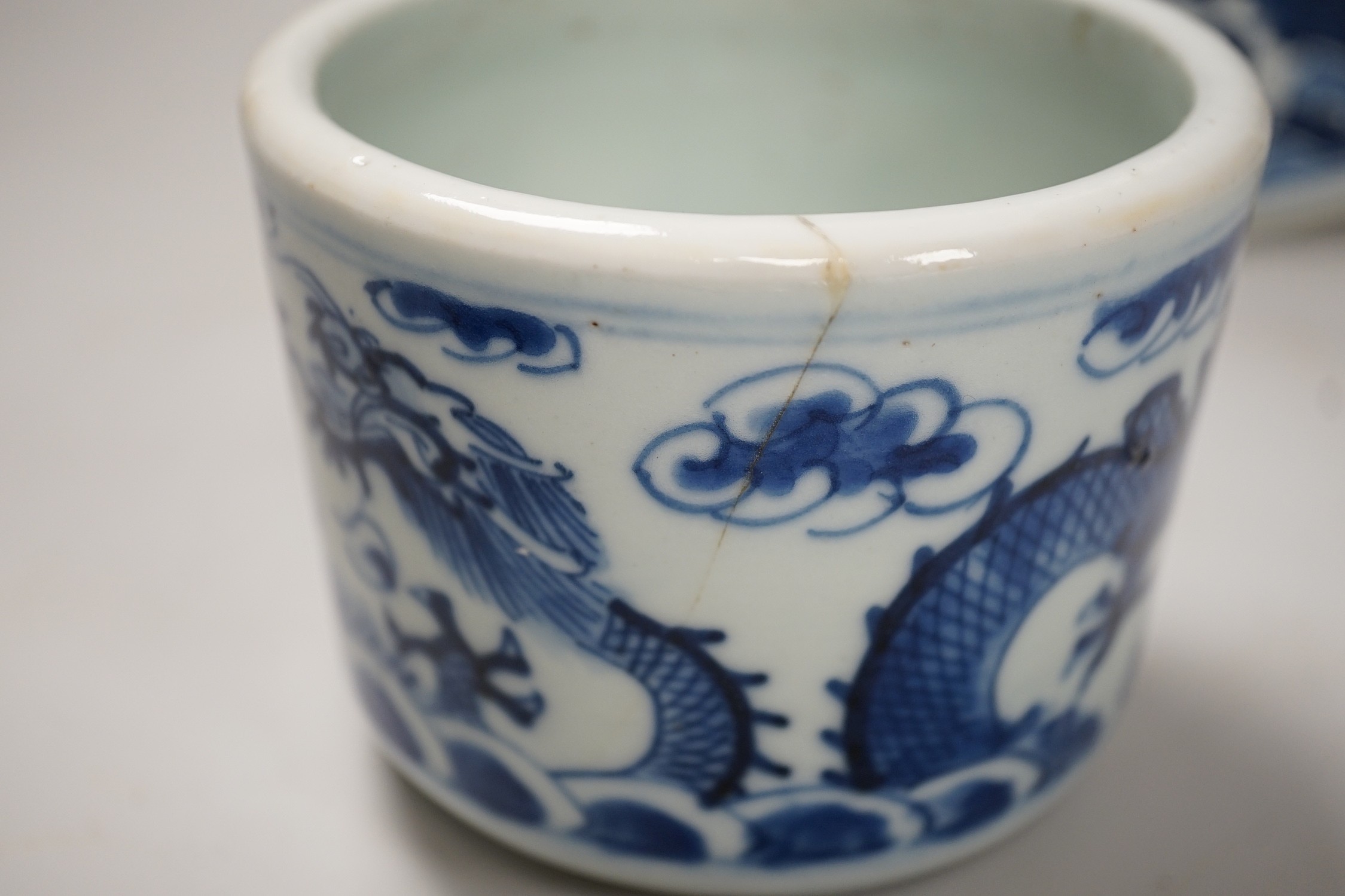 A Chinese blue and white ‘lotus’ charger, together with a bowl and dragon pot on tripod base